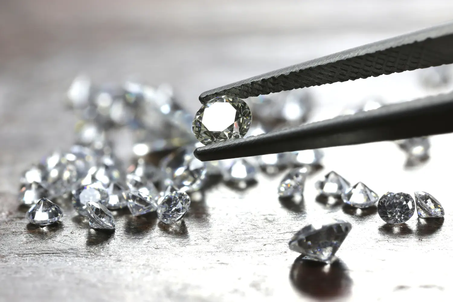 Diamant im Brillantschliff, gehalten von einer Pinzette von Julia Kling
